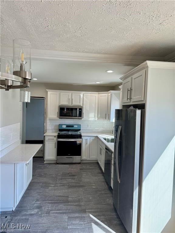 Kitchen featuring backsplash, stainless steel appliances, white cabinetry, and dark wood-type flooring