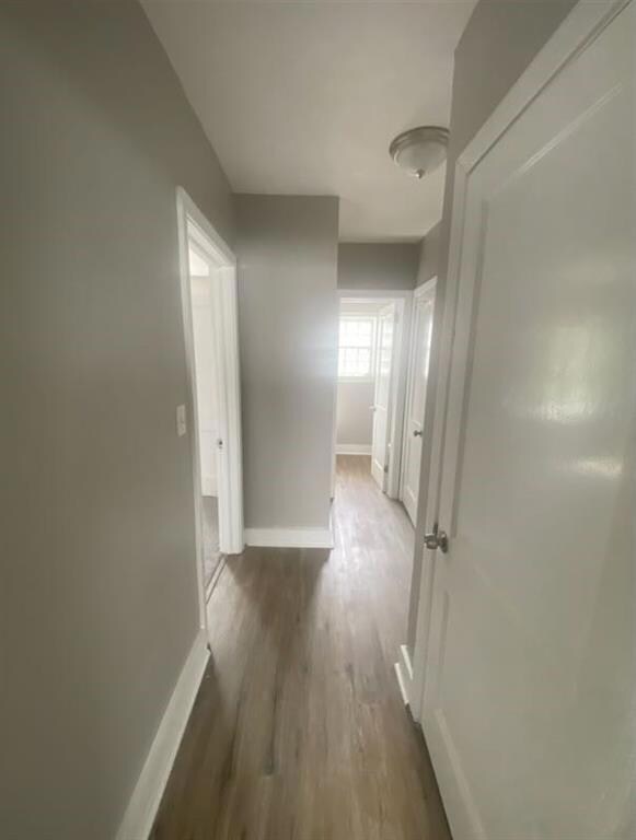 Hall featuring baseboards and dark wood finished floors