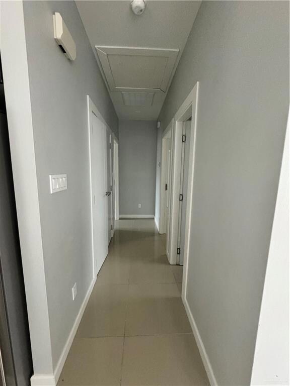 Corridor featuring light tile floors