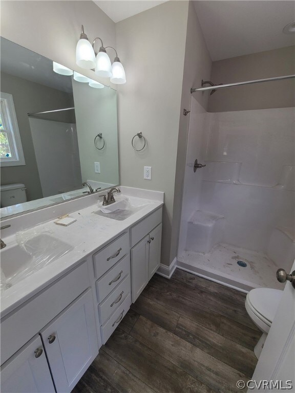 Bathroom featuring dual vanity, toilet, hardwood /