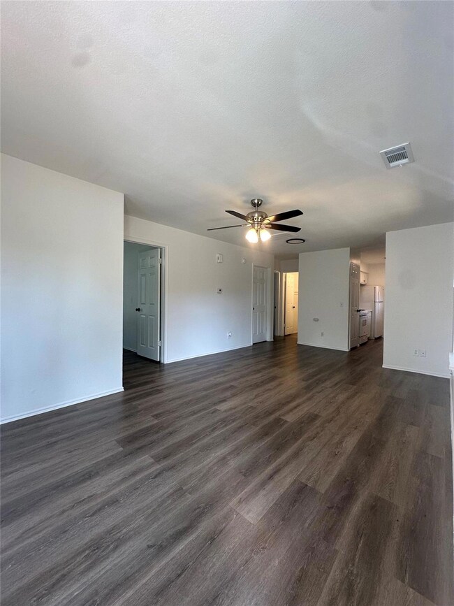 Unfurnished living room featuring dark wood-style