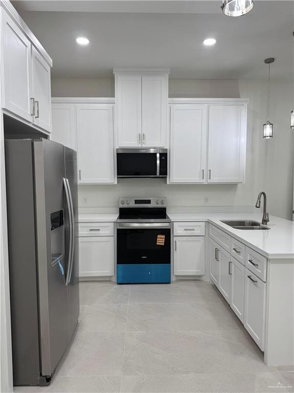 Kitchen featuring stainless steel appliances, white cabinetry, decorative light fixtures, a peninsula, and recessed lighting