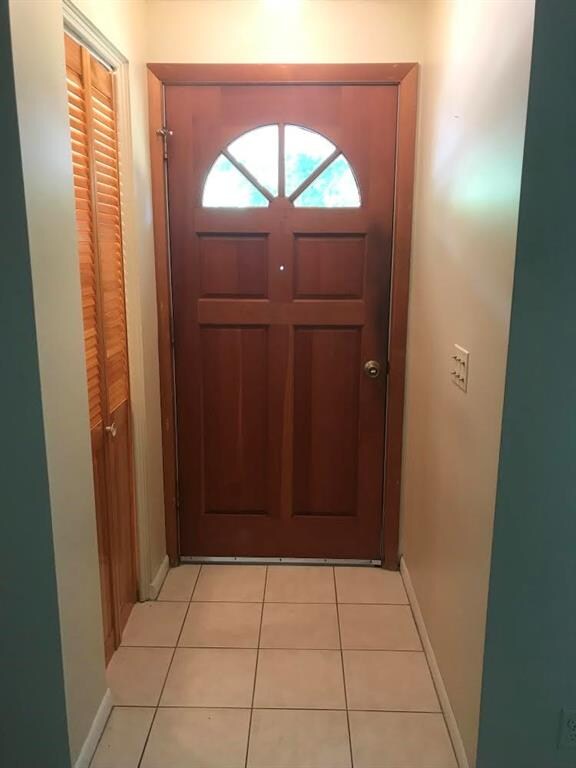 Foyer has tile floor, closet with a light