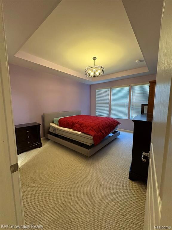 Bedroom featuring a tray ceiling and carpet flooring