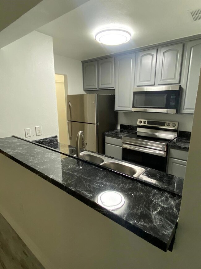Kitchen featuring kitchen peninsula, hardwood / wo