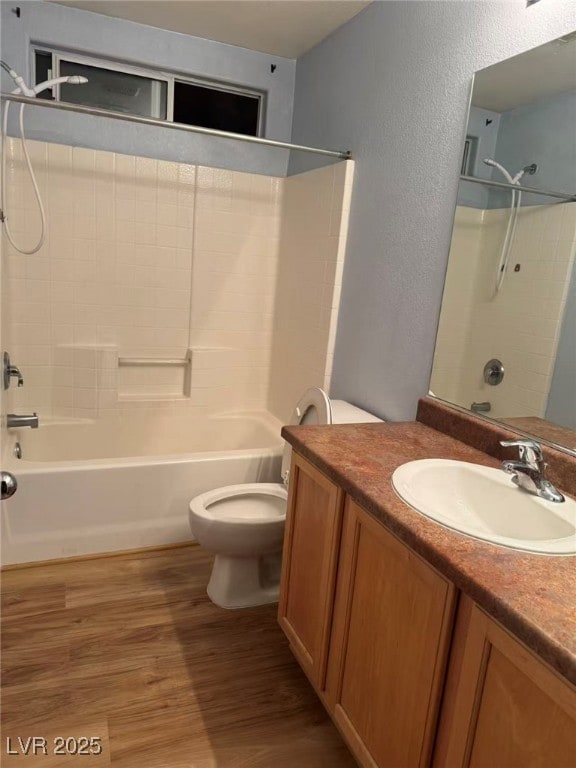 Full bath featuring vanity, shower / bath combination, light wood-type flooring, and a textured wall