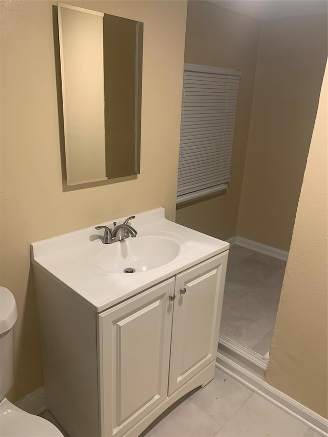 Bathroom with tile patterned floors, toilet, and v