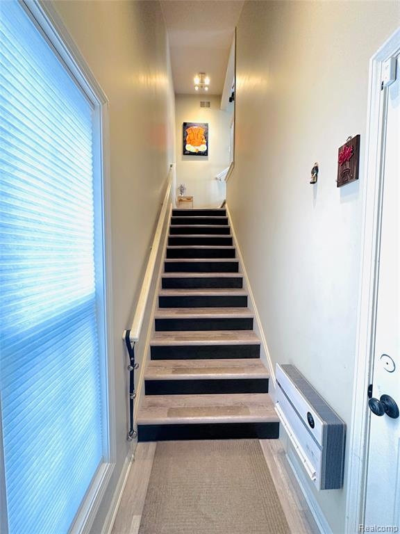 Staircase with baseboards and wood finished floors