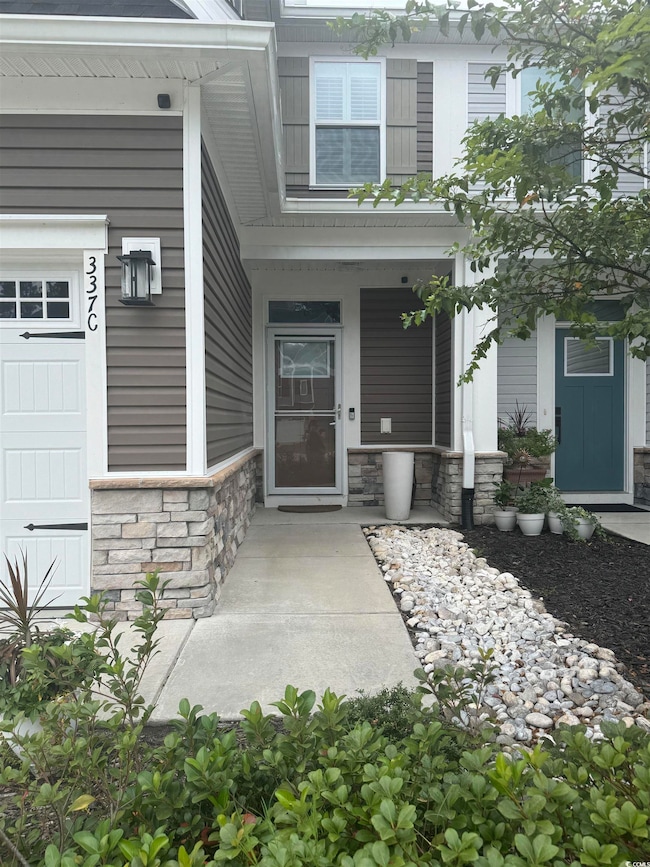 Property entrance featuring stone siding and covered porch