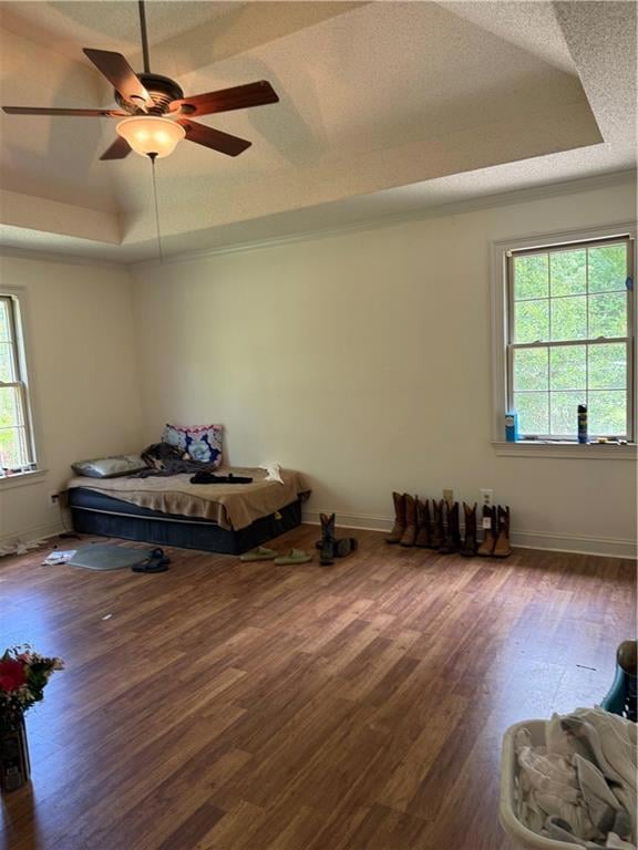 Bedroom featuring a tray ceiling, wood finished fl
