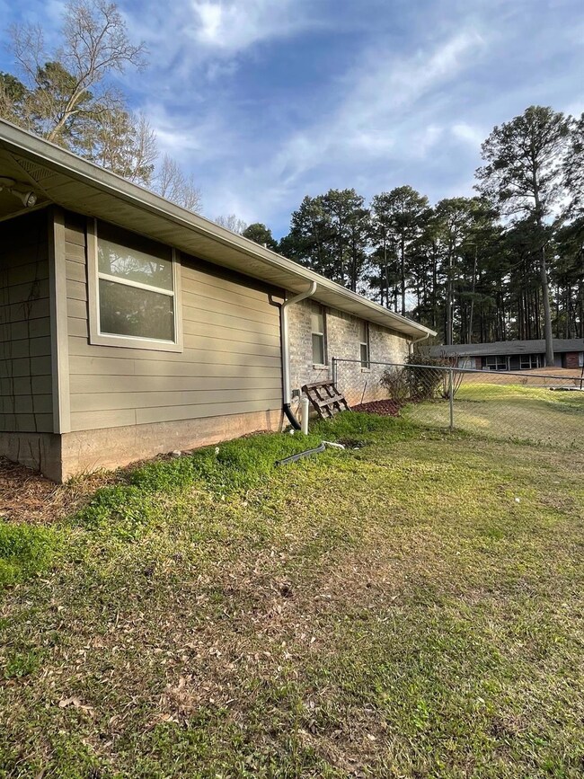 View of side of property featuring a lawn and fenc