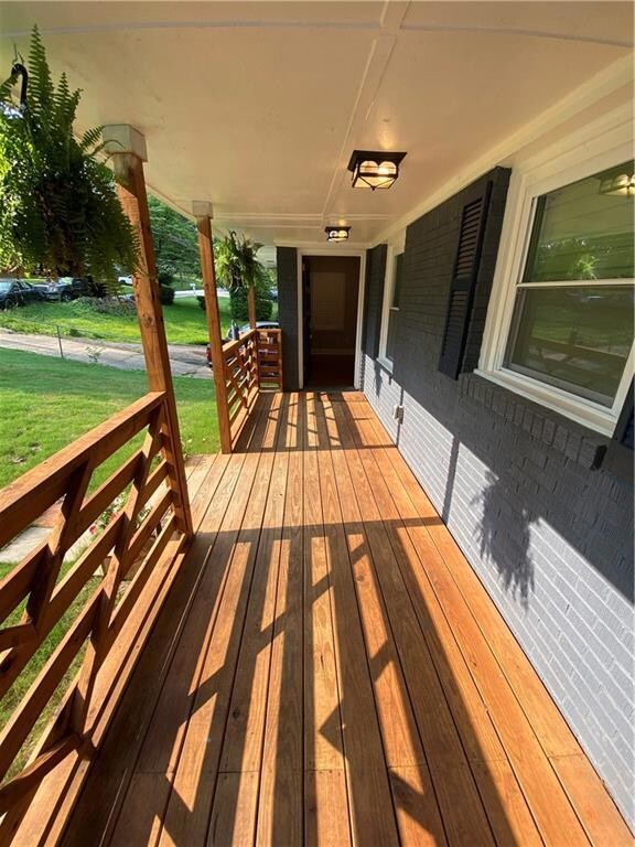 Wooden porch featuring a yard