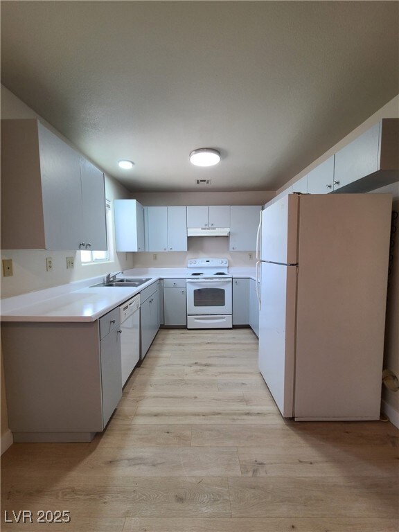Kitchen with white appliances, light wood finished