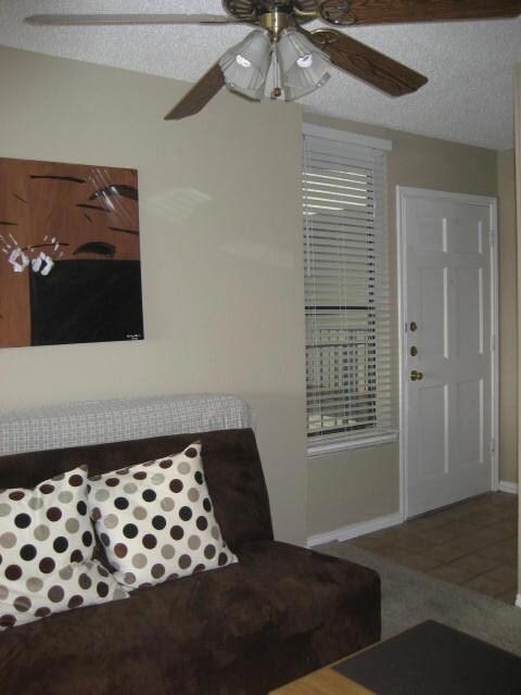 Living area featuring a ceiling fan and a texture