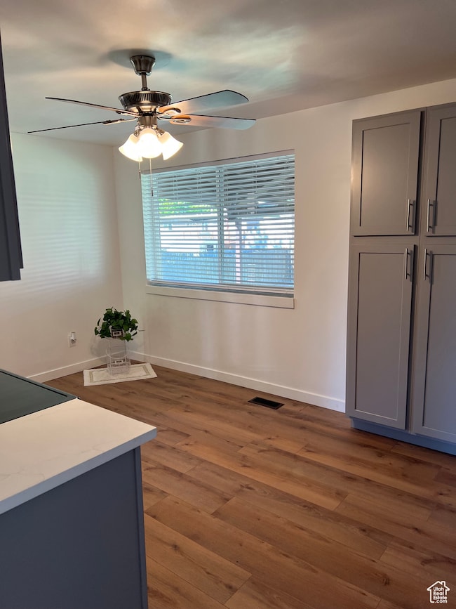 Unfurnished dining area with dark wood finished floors and a ceiling fan