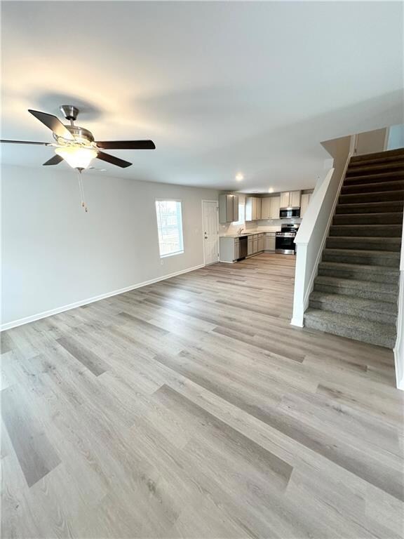 Unfurnished living room featuring stairs, a ceilin