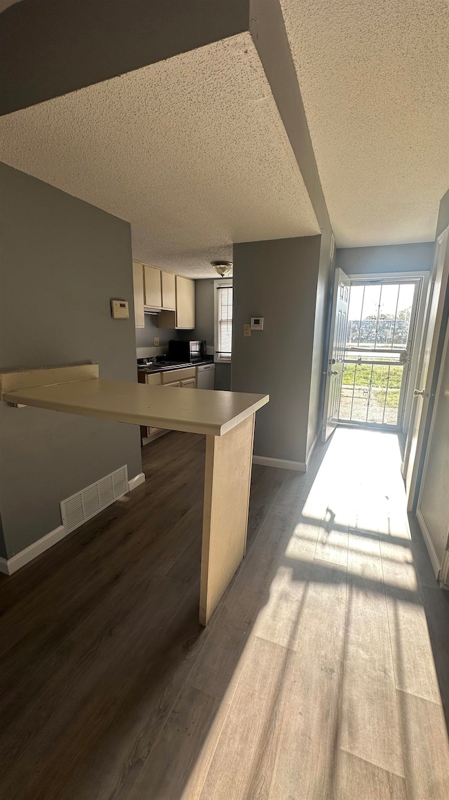Kitchen featuring baseboards, dark wood-style floo