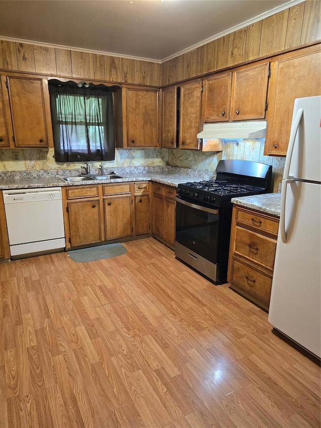 Kitchen featuring dishwashing machine, light wood-
