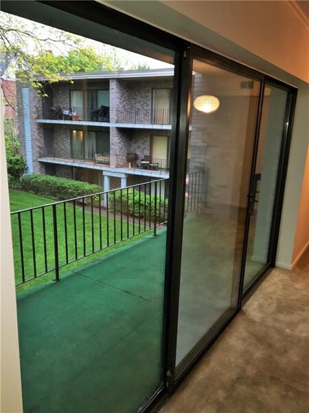 Sliding glass doors overlooking common greenspace.
