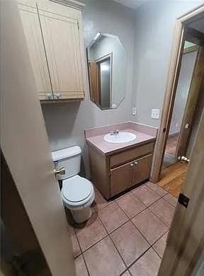 Bathroom with vanity, toilet, and tile patterned f
