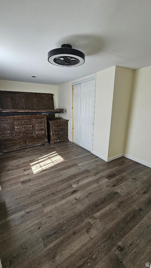 Unfurnished bedroom featuring wood finished floors and baseboards