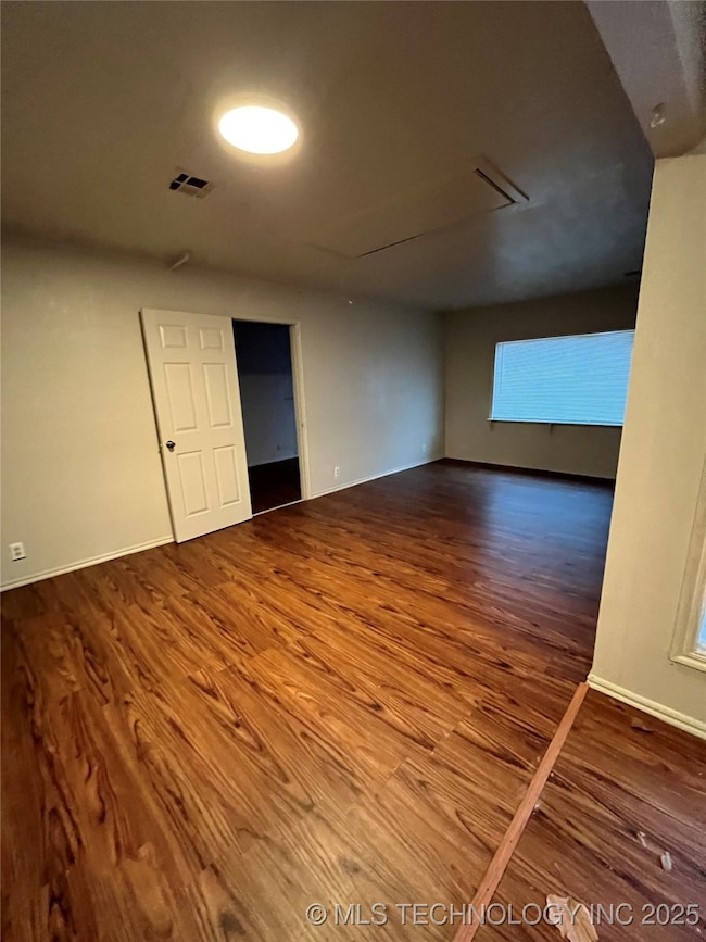 Empty room featuring wood finished floors and base
