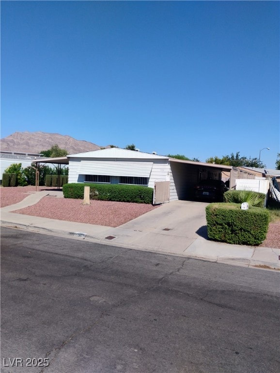 View of front of house with a carport, driveway, a