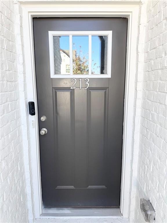 Doorway to property featuring brick siding