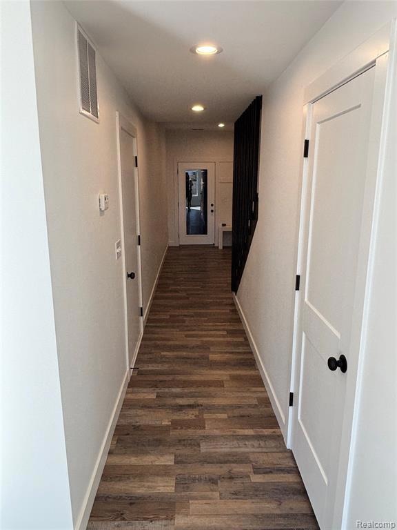 Hall featuring dark wood finished floors and recessed lighting