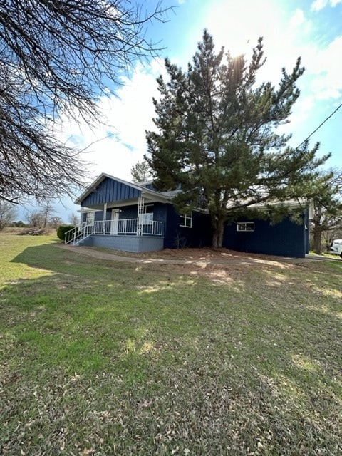 Rear view of house with a yard and board and batten siding