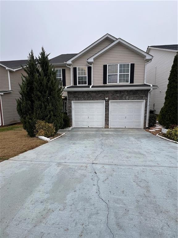 View of front of house with a garage, concrete dri