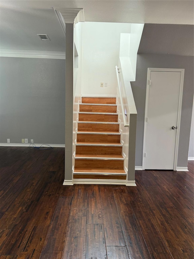 Staircase with baseboards, visible vents, wood-typ