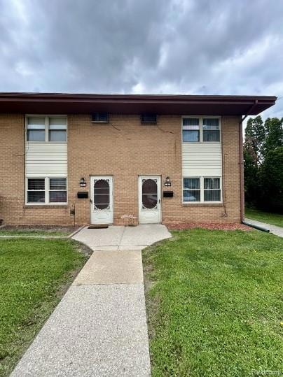 Traditional-style home with a front yard and brick siding