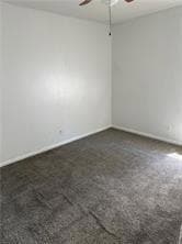 Empty room featuring ceiling fan and baseboards