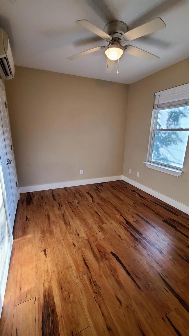 Empty room with a ceiling fan, baseboards, a wall