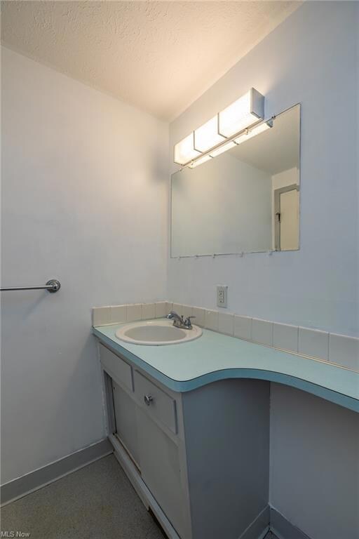 Bathroom with vanity and a textured ceiling
