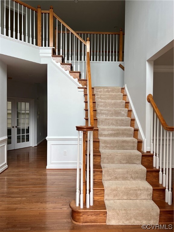 Entry stairs featuring foyer light with hardwood flooring and a 9ft. ceiling