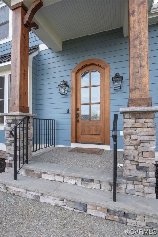 Entrance to property featuring covered porch