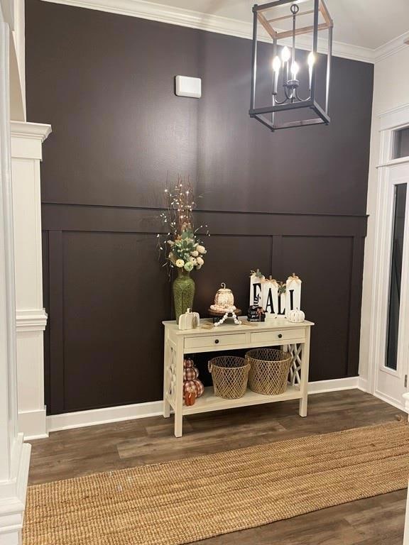 Detailed view of ornamental molding, wood finished floors, and a chandelier