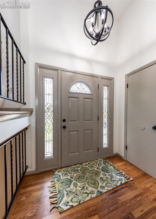 Entryway featuring a chandelier, wood finished floors, and a high ceiling