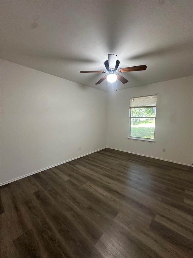 Unfurnished room featuring dark wood-type floorin
