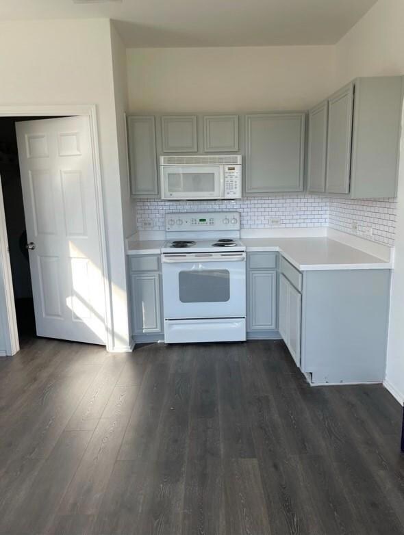 Kitchen featuring gray cabinetry, white appliances