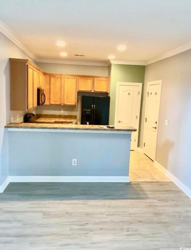 Kitchen featuring baseboards, backsplash, black ap
