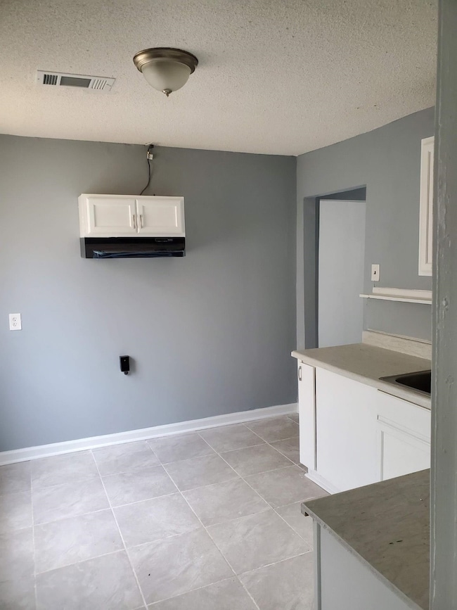 Laundry area with light tile patterned floors, a s