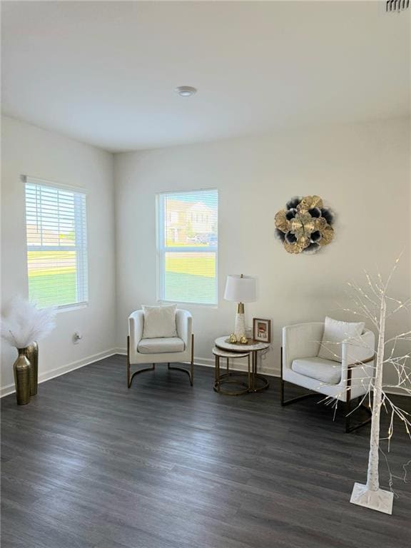 Sitting room with dark wood-type flooring and baseboards