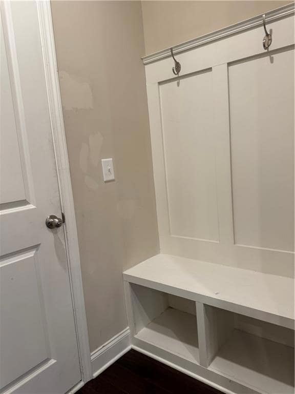 Mudroom featuring dark wood-style floors and baseb