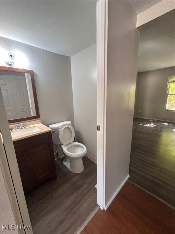 Half bathroom with dark wood-style floors and vanity