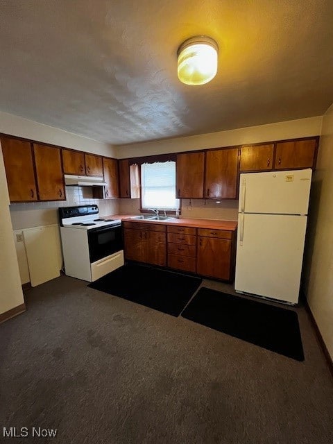 Kitchen featuring fridge, stove, brown cabinetry, and light countertops