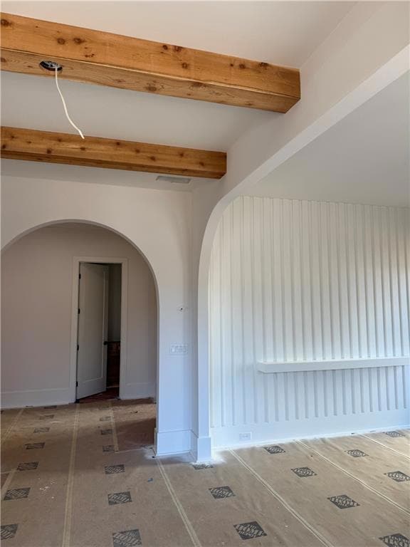 Lot 5 – A stunning entryway with arched walls, a slated accent wall, and beamed ceilings.