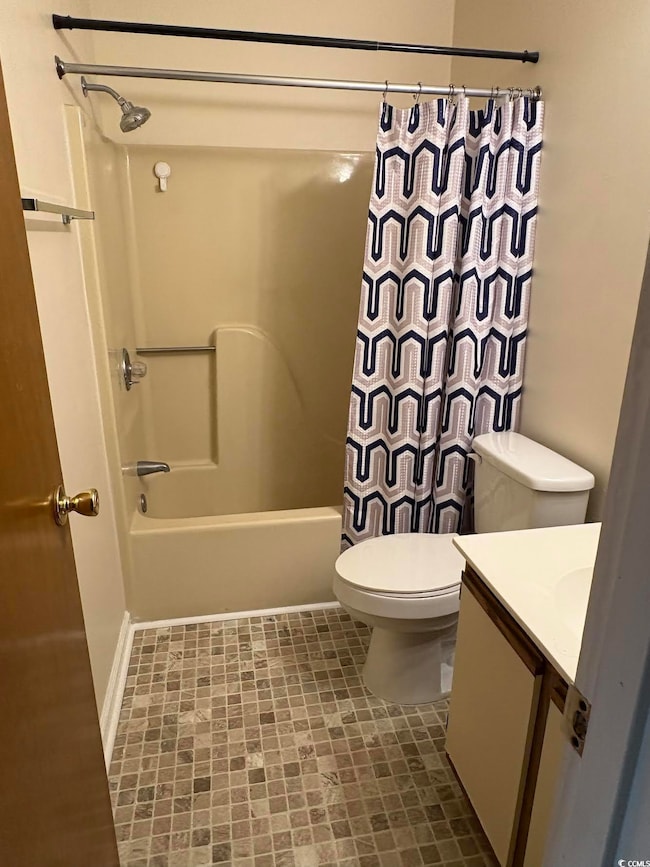 Full bath with toilet, vanity, and shower / bath combo with shower curtain